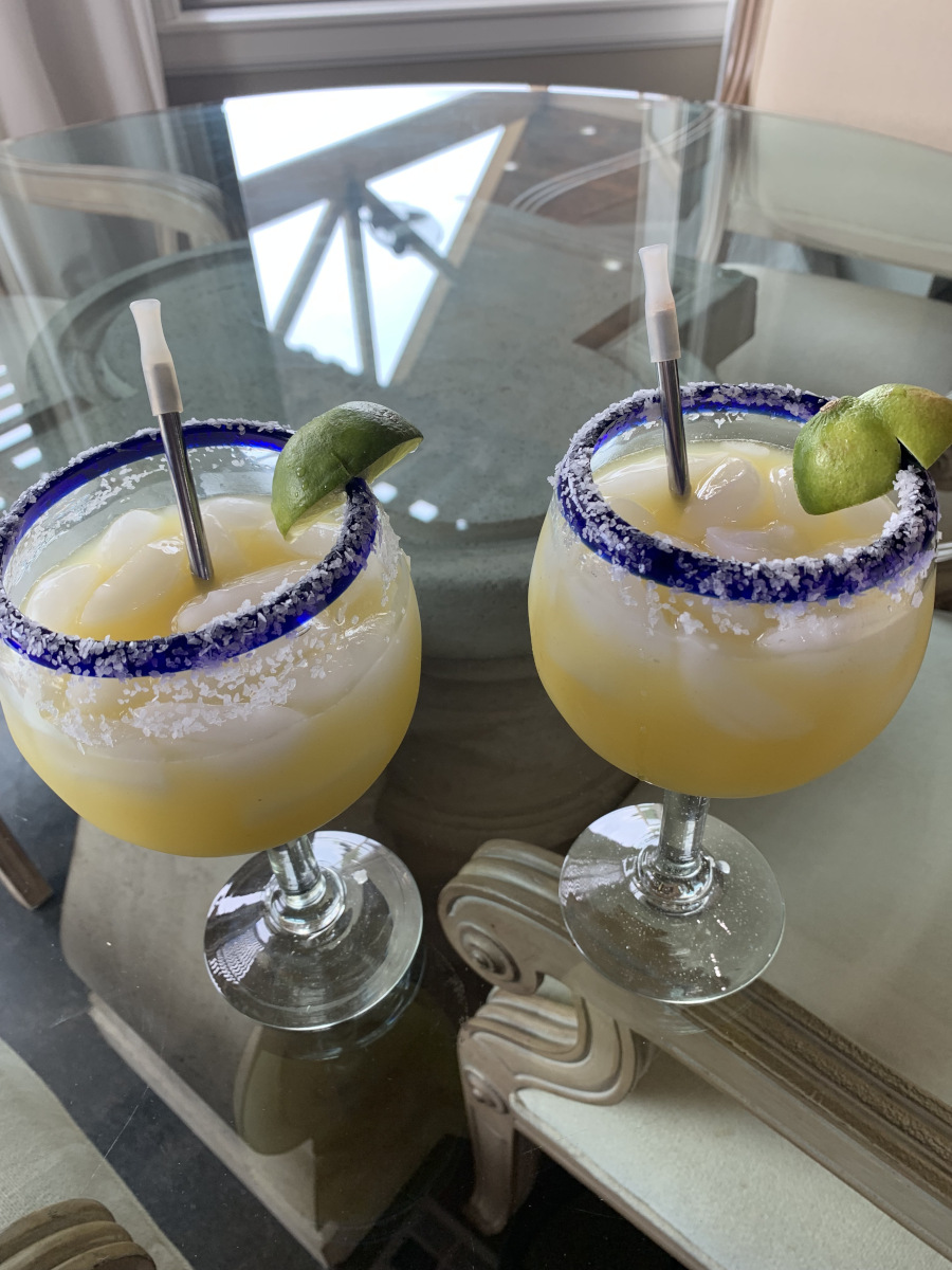 House Margarita - Two beverages served in hurricane glasses with salted rims